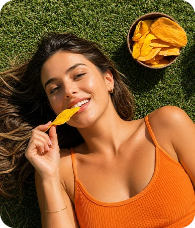 Žena ochutnává sušené mango